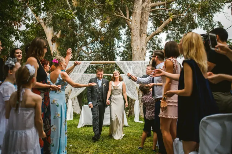 Bride and groom walking back up the aisle as guests cheer