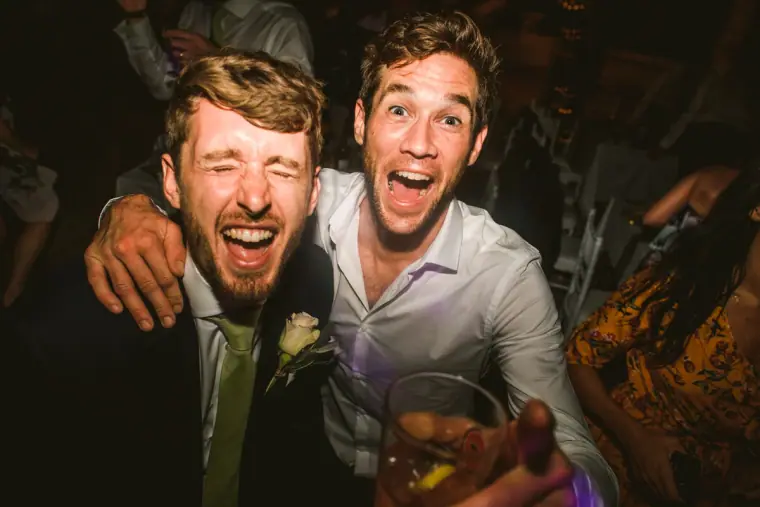 Two guests laughing and pulling faces at the camera on the dance floor