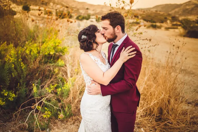 Couple kissing among wild shrubs in the dry Cypriot countryside