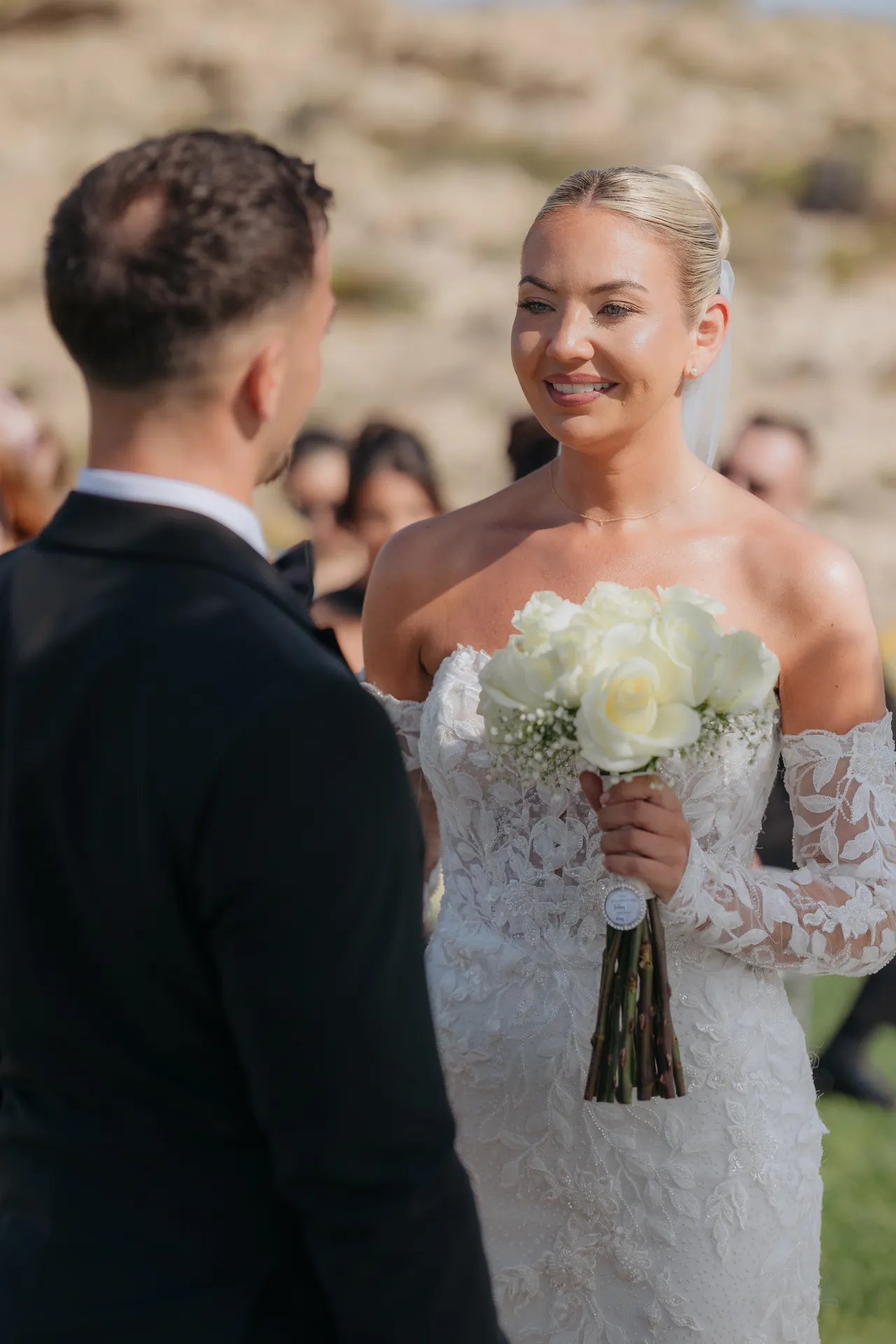 Bride holding her bouquet as she faces Ashley at the start of the ceremony