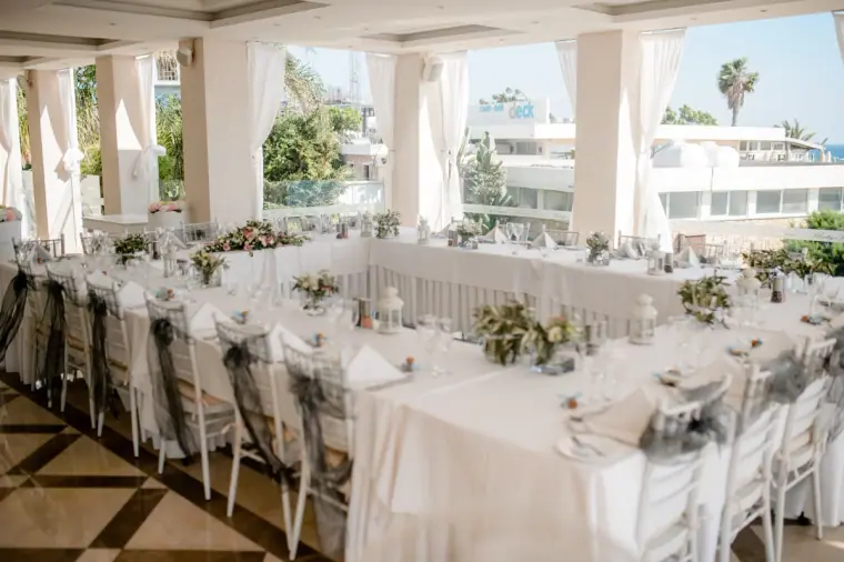 Reception tables laid with white linen on a terrace at Alexander the Great hotel, Paphos