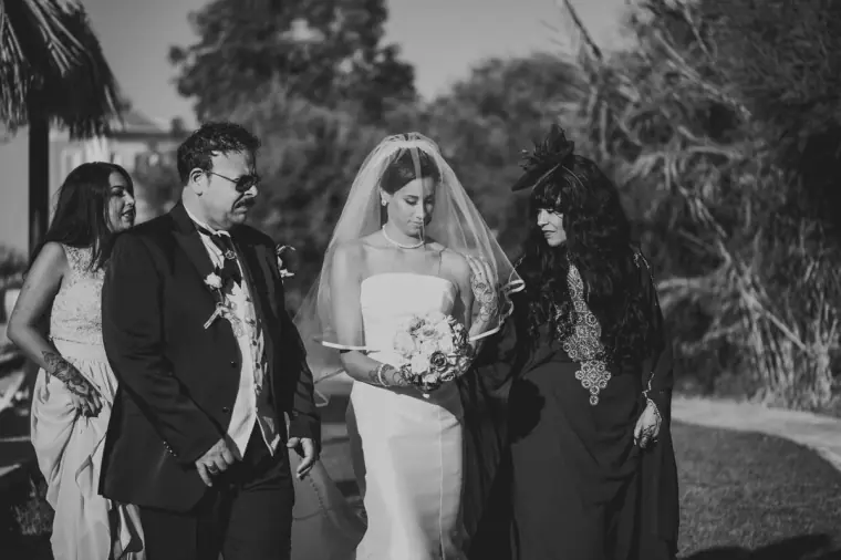 Black-and-white photo of the bride walking out on her father's arm