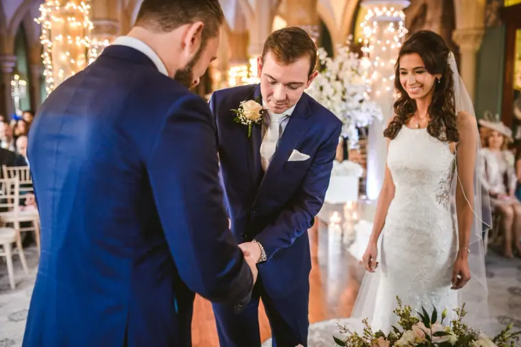 Elina and Iain standing before the celebrant as the ceremony begins at Wotton House