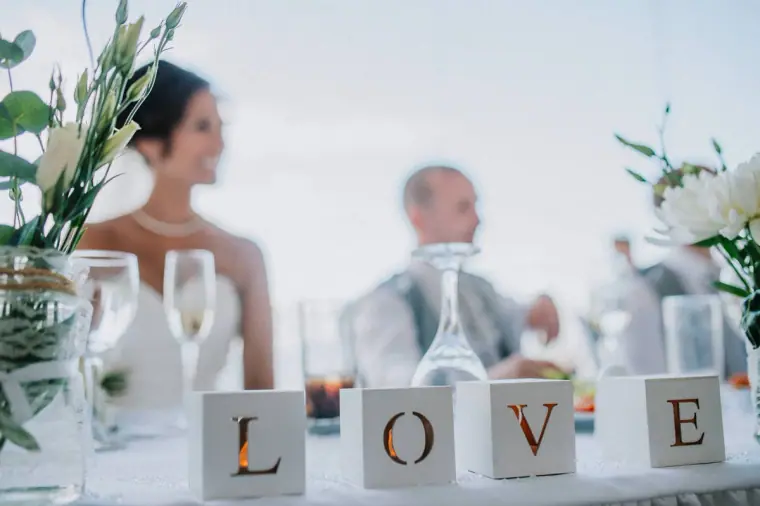 Wooden LOVE letter blocks on the top table as the couple listen to speeches