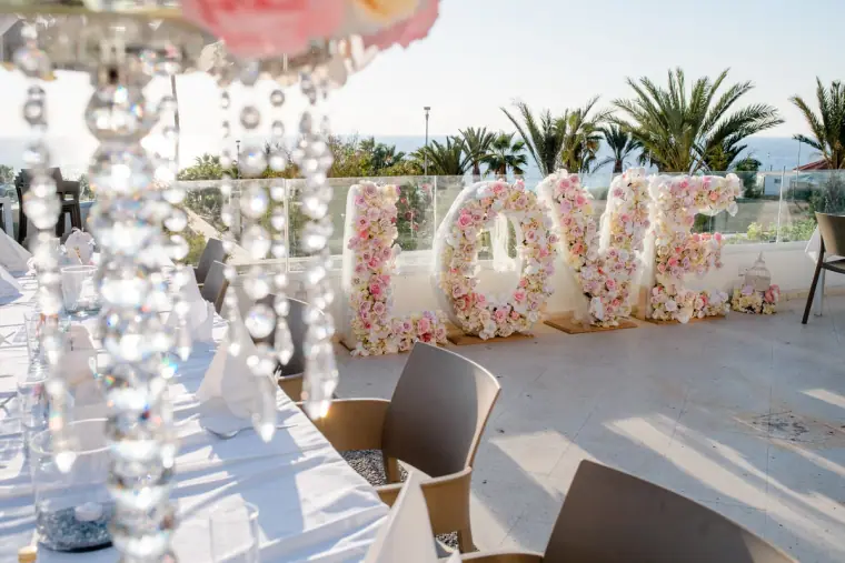 Floral LOVE sign and crystal centrepieces on the reception terrace at Laura Beach Hotel, Paphos