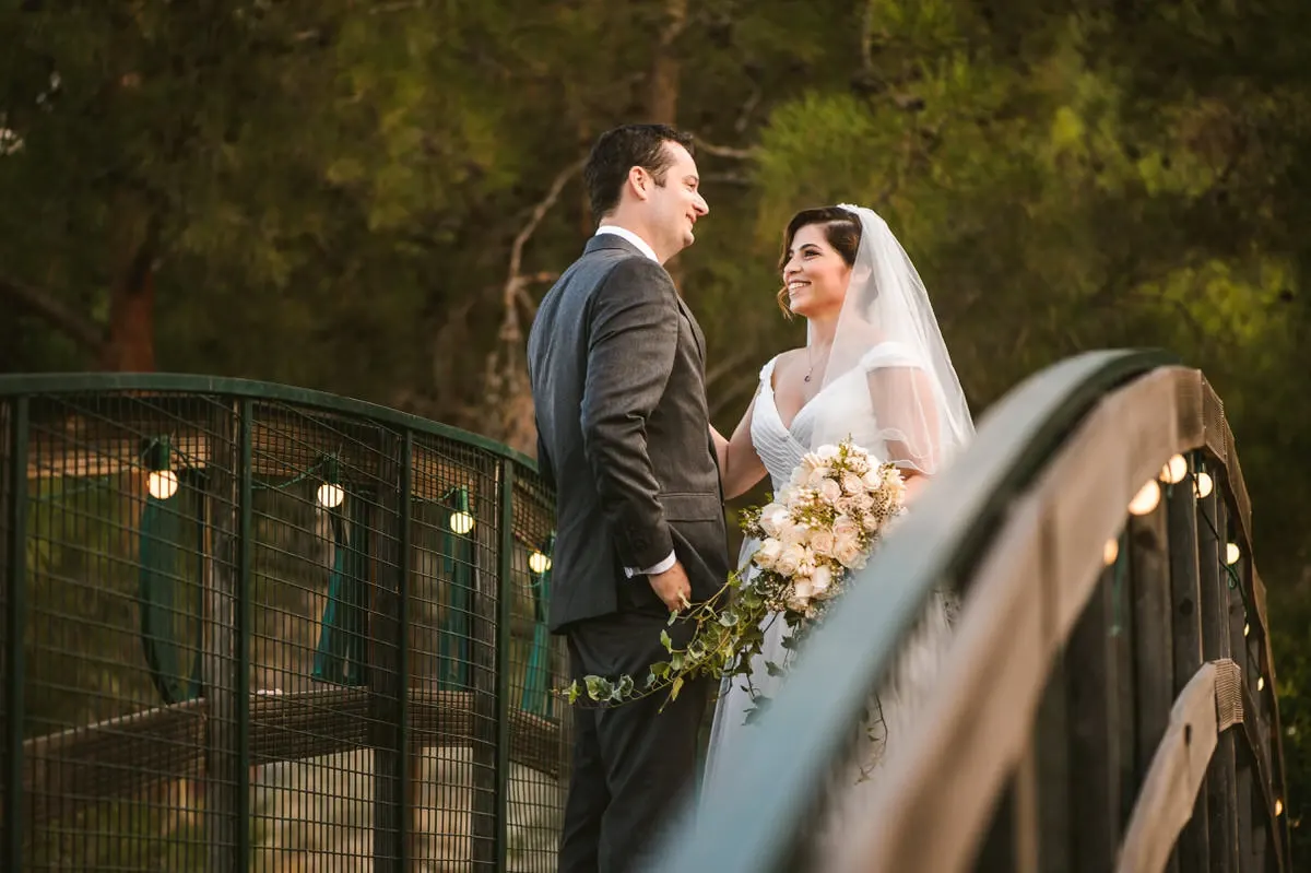 Nermine and Christopher on a lantern-lit footbridge among pine trees at Lexeko Estate, Cyprus
