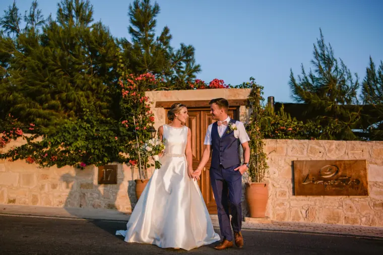 Nicola and Joel hand in hand at the wooden entrance gate of Liopetro, Kouklia