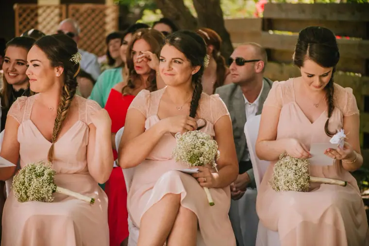 Bridesmaids in blush dresses holding gypsophila posies during the ceremony