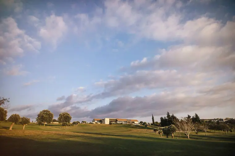 Wide view of the Minthis Hills clubhouse across the fairway under a cloudy sky