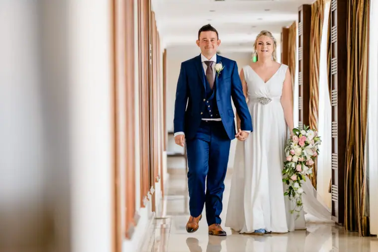 Francesca and Stephen walking into the reception along a bright corridor