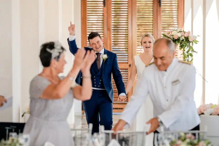 Guests applauding as the bride and groom enter the reception
