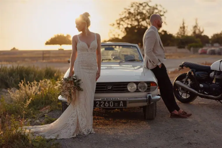 Sarah and Ben beside the vintage white convertible at sunset, Liopetro