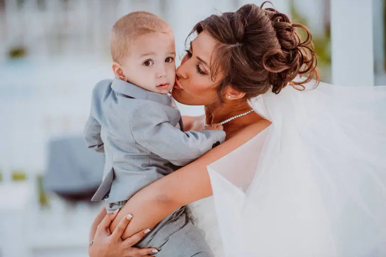 Louise kissing the young pageboy as she holds him