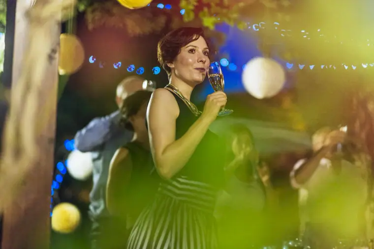 Guest giving a speech with a microphone under paper lanterns and fairy lights