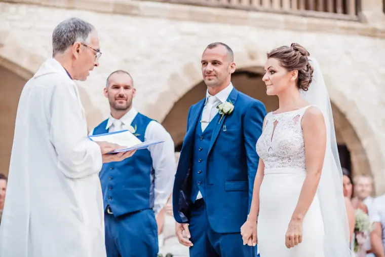 Priest reading as the bride and groom stand before him with the best man