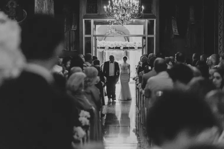 Black-and-white photo of Ruby walking down the aisle on her father's arm