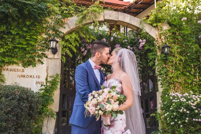 Couple kissing in the ivy-covered stone archway of Vasilias Nikoklis Inn