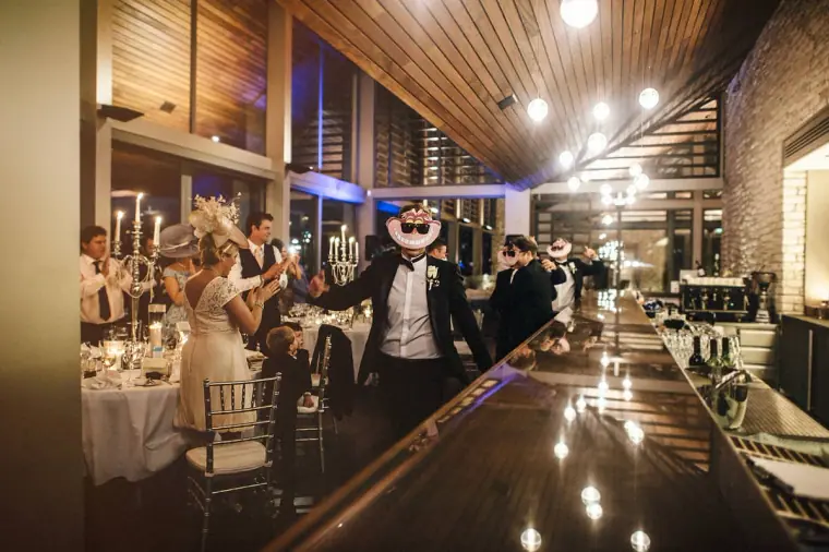 Bride and groom dancing their way into the reception between long glowing tables