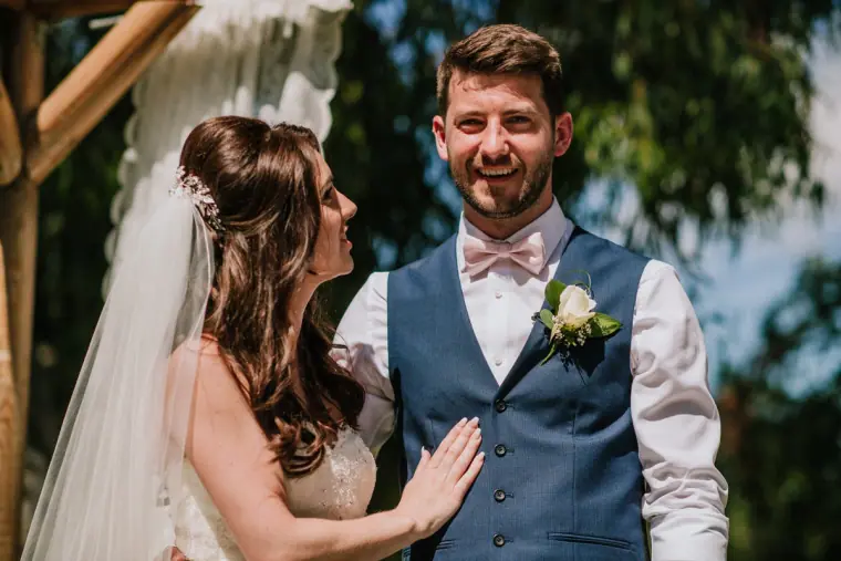 Sean beaming as Claire rests her hand on his chest after the vows