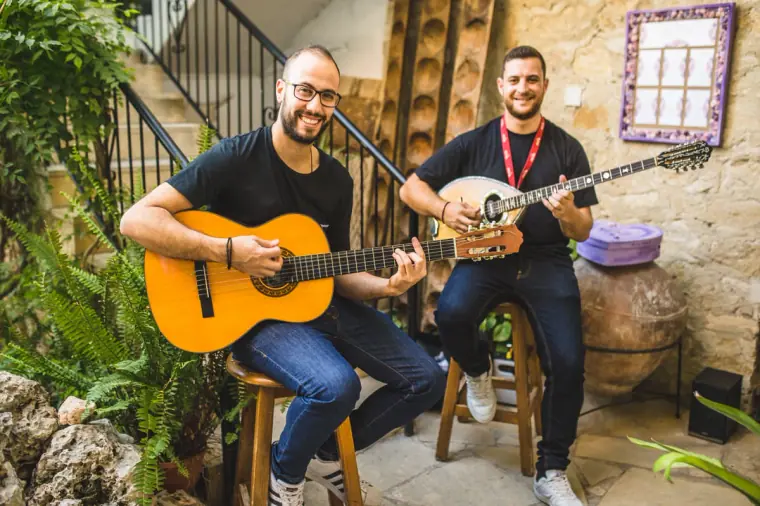 Guitarist and laouto player performing in the inn's stone courtyard