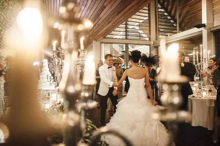 Bride and groom on the dance floor seen through glowing candelabras