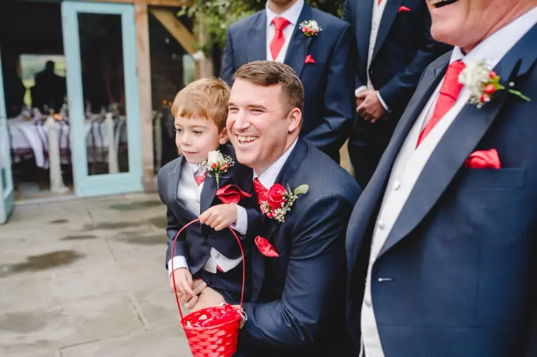 Groom crouching with a young pageboy among the groomsmen