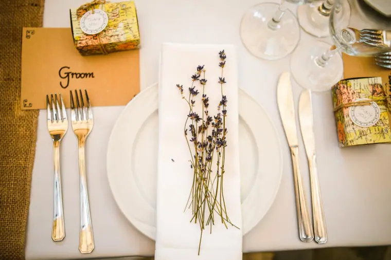 Place setting with a "Groom" name card, lavender sprig and gold favour box