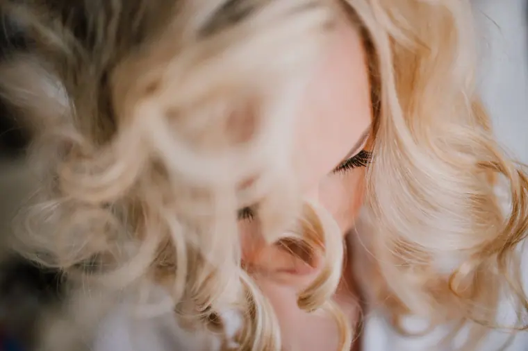 Close-up of a bride's soft blonde curls as she looks down, Santorini
