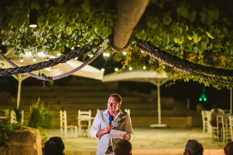 Guest giving a speech under a pergola strung with fairy lights