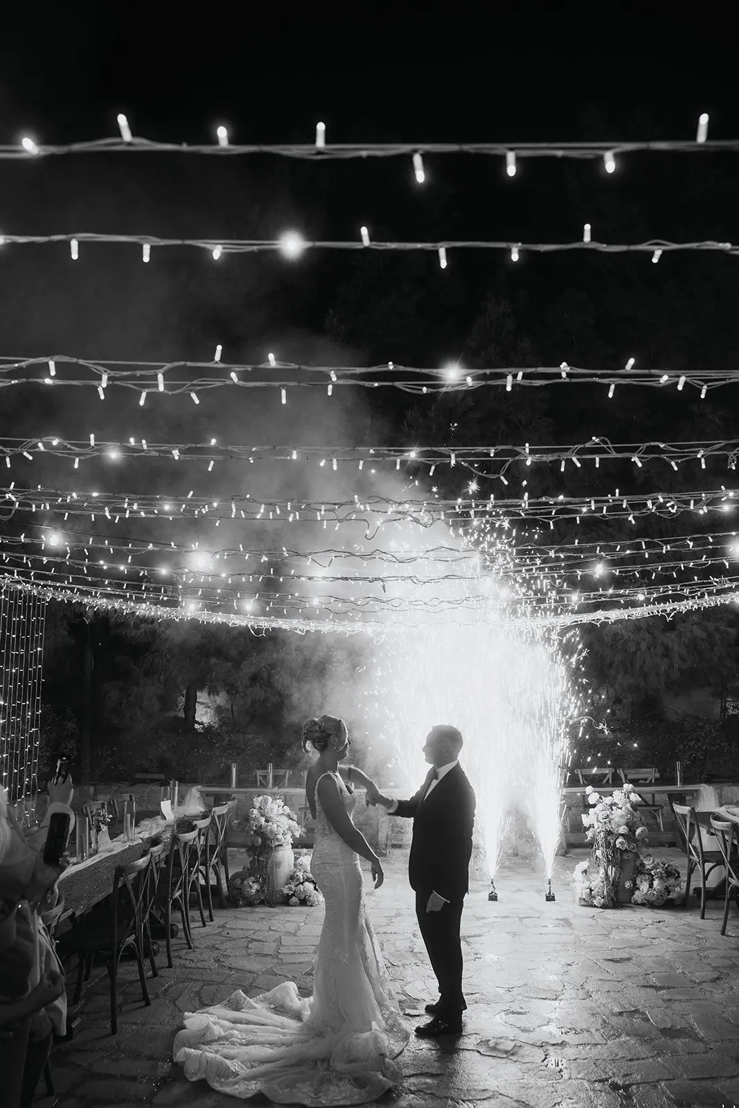 Black-and-white photo of Zoe and Oliver's first dance with cold sparks behind them