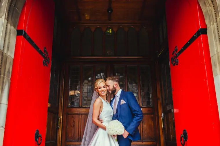 Leonnie and Andy embracing in front of open red doors at Mansfield Traquair