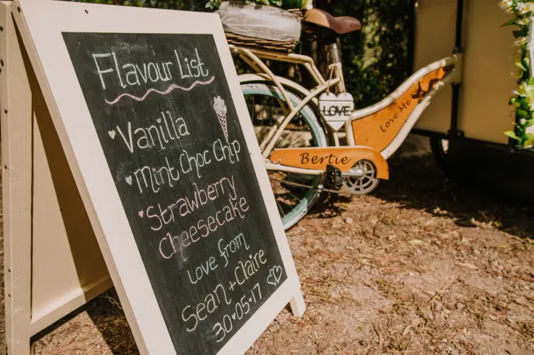 Chalkboard ice cream flavour list beside a vintage bicycle cart