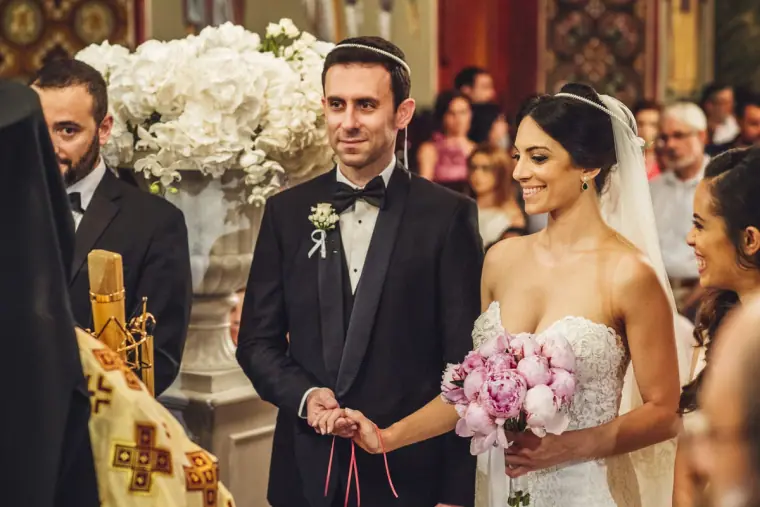 Ruby and Angelos smiling side by side at the altar