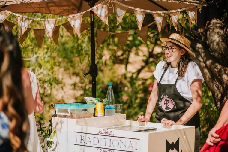 Smiling server at a traditional ice cream cart under bunting