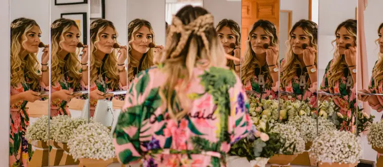 Bride in a floral robe reflected many times in a row of mirrors