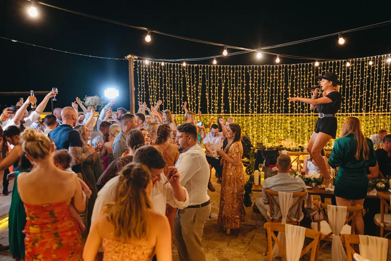 Evening party under string lights and a fairy-light curtain at Liopetro