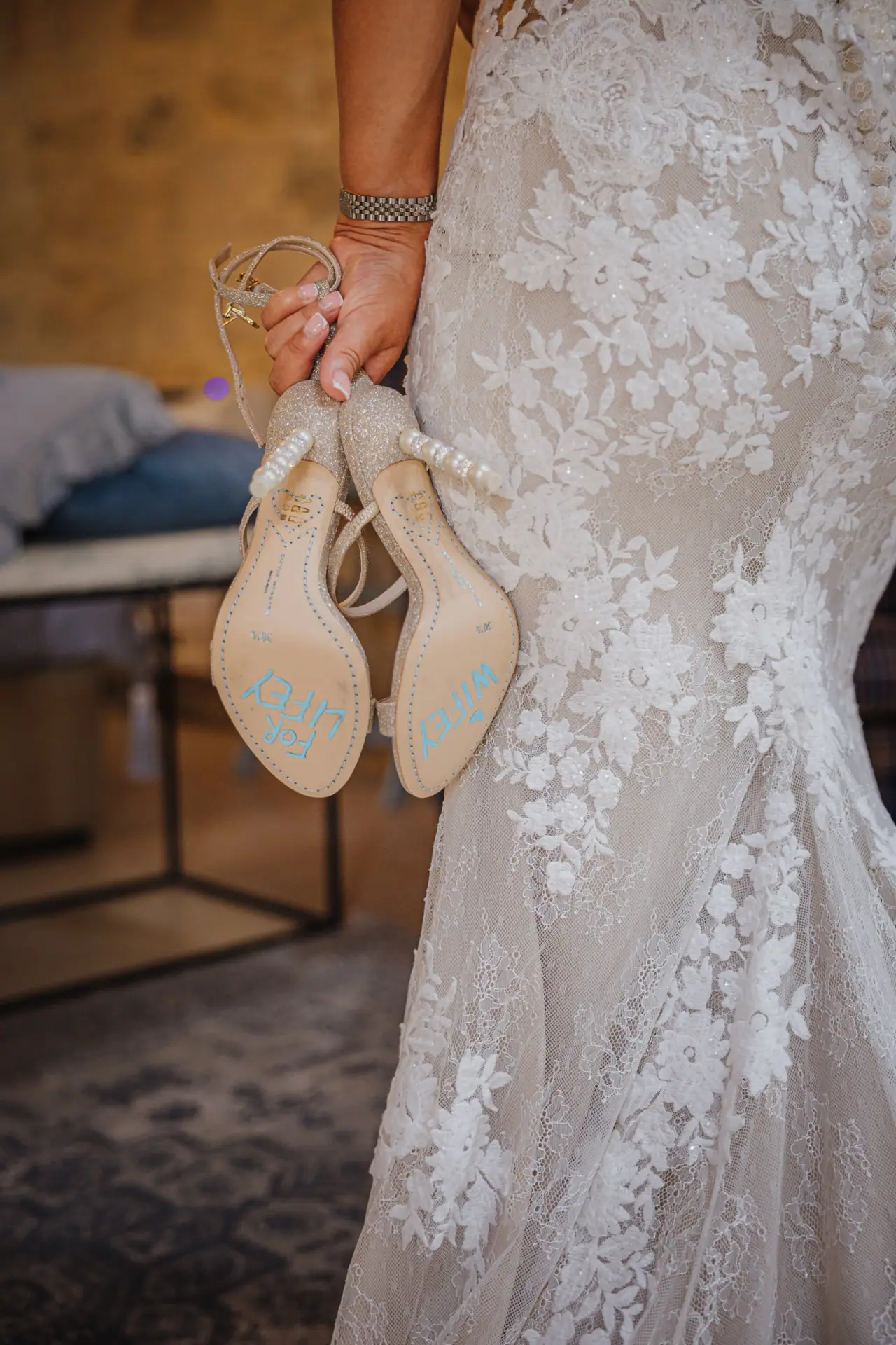 Bride holding her heels beside her lace gown at Liopetro