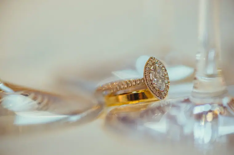 Diamond engagement ring resting on a glass base