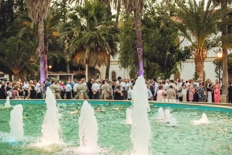 Guests gathered around a lit fountain among palm trees at the Nicosia reception