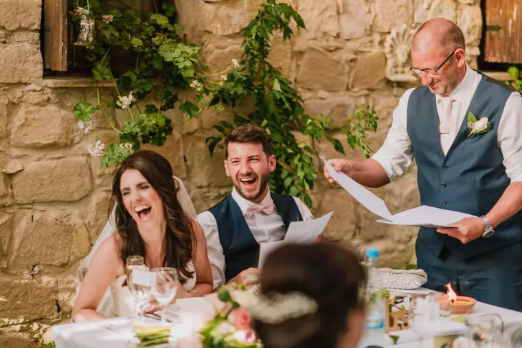 Claire and Sean laughing at the top table as the best man reads his speech