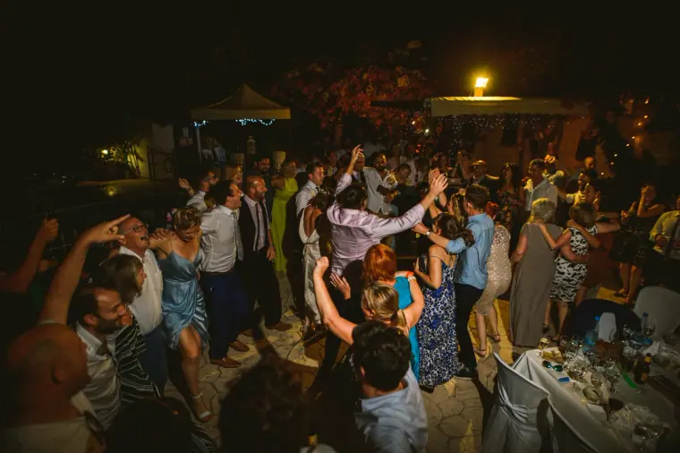 Packed dance floor with guests throwing their arms in the air