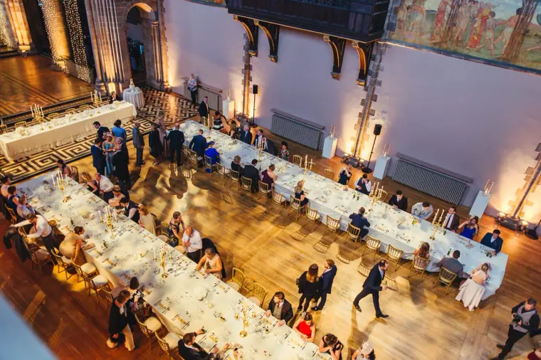 Overhead view of guests finding their seats at the long banquet tables