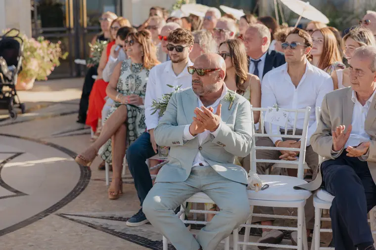 Seated guests applauding as the ceremony begins