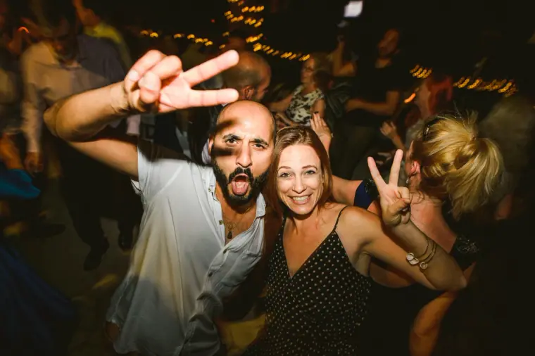 Guests making peace signs and grinning at the camera during the party