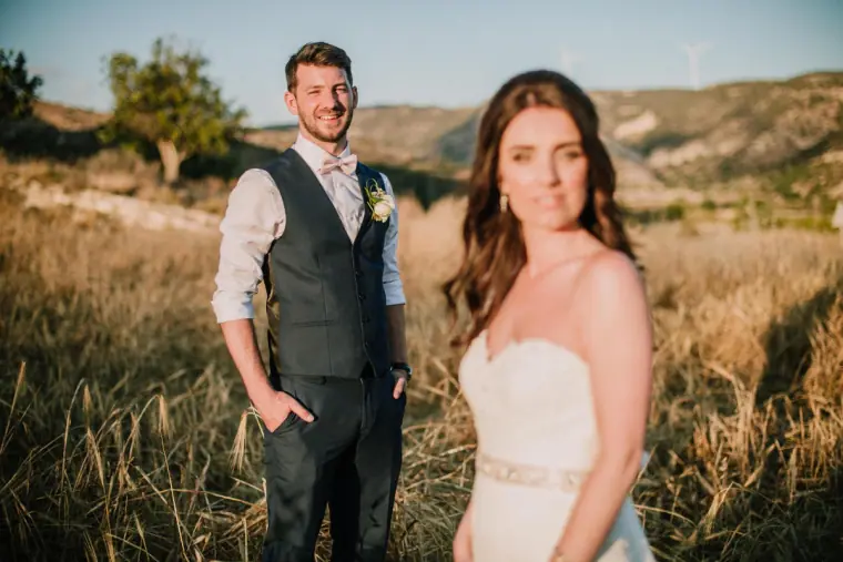 Sean smiling at Claire as she looks away in a sunlit field