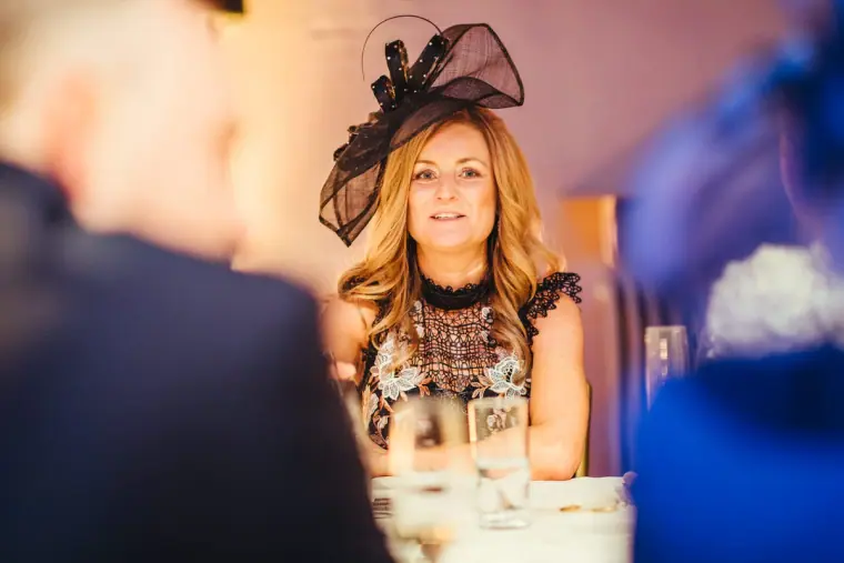 Guest in a black fascinator listening to the speeches