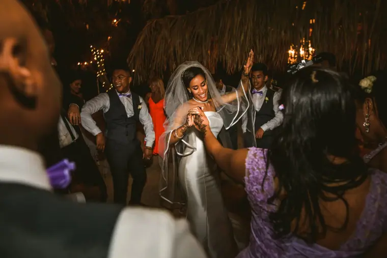Bride dancing with guests on the dance floor at night