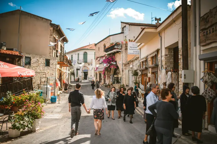 Couple strolling up a busy village street lined with shops in Lefkara, Cyprus