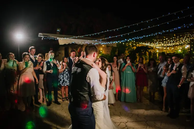 Claire and Sean's first dance beneath festoon lights as guests watch