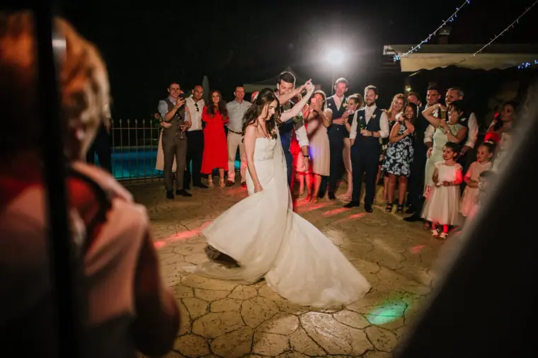 Claire twirling in her gown on the dance floor surrounded by guests